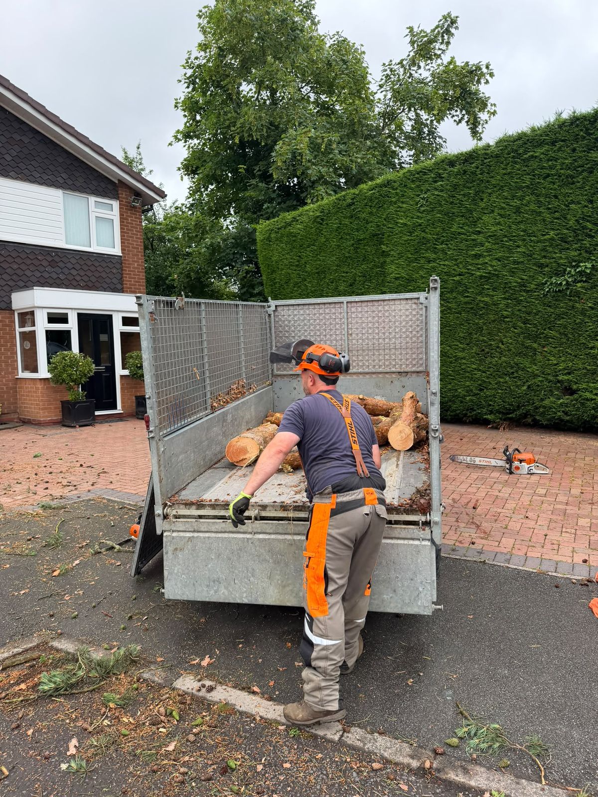 Firewood logs from Middlemore Tree Surgery tree work being loaded onto a trailer